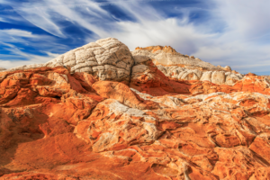White Pocket sandstone formations in Vermilion Cliffs National Monument, Arizona, with vivid red and white rock layers under dramatic desert skies.