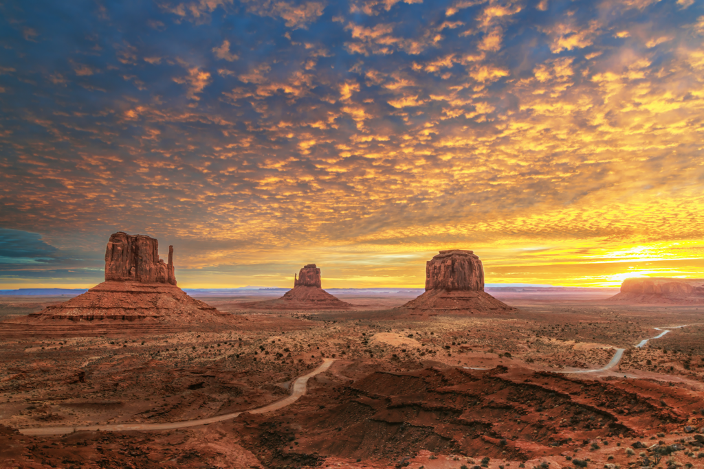 Monument Valley Mittens and buttes at sunrise with glowing desert sky