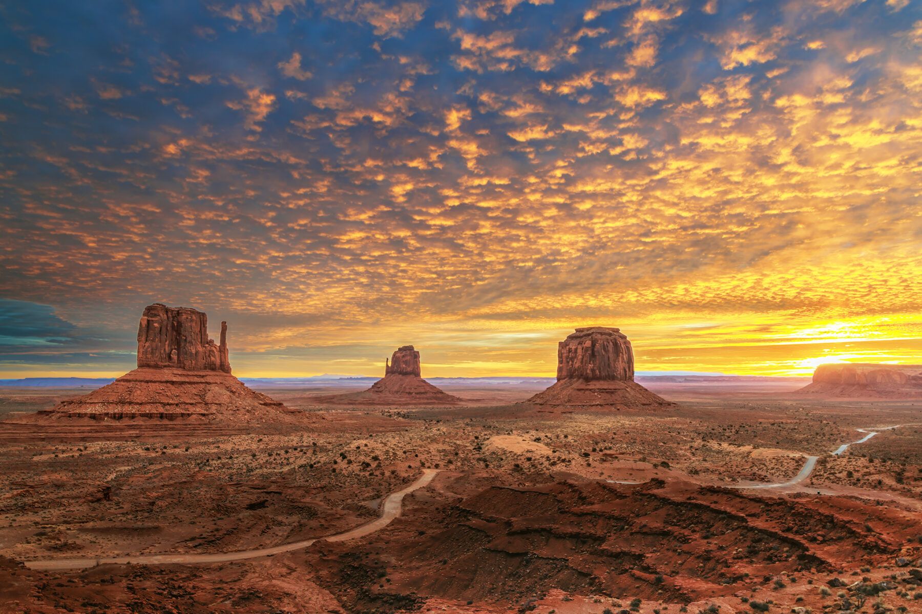 Monument Valley Mittens and buttes at sunrise with glowing desert sky