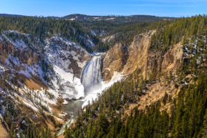 Lower Falls of the Yellowstone River surrounded by snow and colorful canyon walls, Yellowstone National Park landscape photography