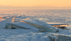 Sunset light glowing on frozen ice slabs along Utah Lake in winter, fine art landscape photography