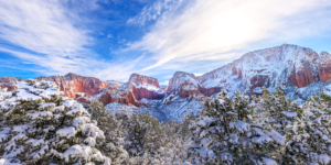Snow covered Kolob Canyons in Zion National Park with red cliffs and winter sky