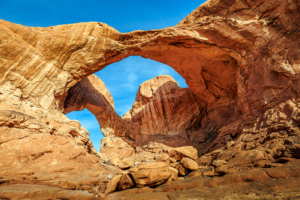 Double Arch rock formation in Arches National Park under blue sky