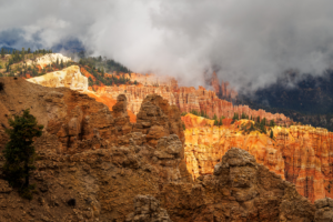 Hoodoos and cliffs at Bryce Canyon National Park with dramatic storm clouds overhead.